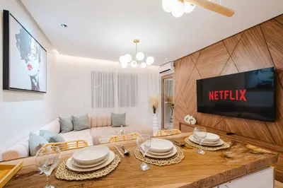 a living room with a white couch and a tv at NEW - Central 1BR-Kingsize, AC & Terrace Parking in Marrakech