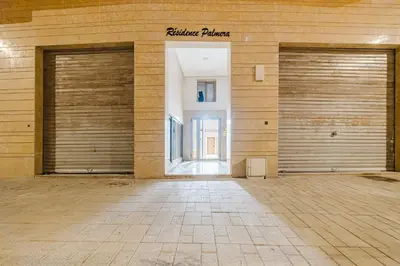 two sets of garage doors in a building at NEW - Central 1BR-Kingsize, AC & Terrace Parking in Marrakech