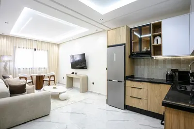 a kitchen and living room with a couch and a table at The Pleasant Stay - Hivernage Marrakech in Marrakech