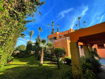 a yard with palm trees and a building at Villa Corail in Marrakech