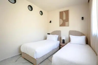 two beds sitting next to each other in a room at The Icon Boutique Hivernage in Marrakech