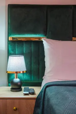 a bed with a green headboard and a lamp on a table at NEW 2Br Family-Friendly, in the Heart of Marrakech in Marrakech