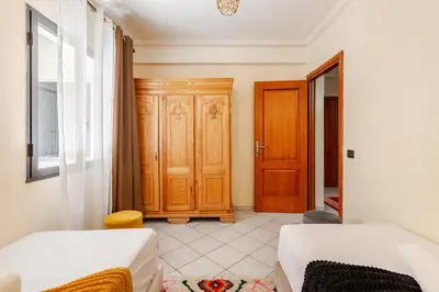 a bedroom with two beds and a wooden door at Gueliz - Authentic 3 Majorelle central Marrakech in Marrakech