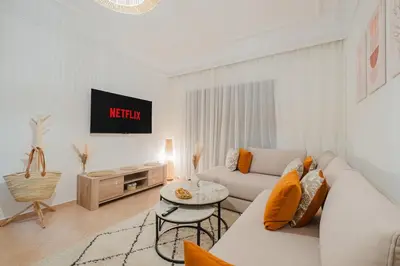 a white living room with a couch and a table at NEW 2Br Family-Friendly, in Center of Marrakech in Marrakech