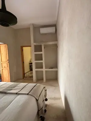 a bedroom with a bed and a book shelf at Riad Dar tiegezh in Marrakech