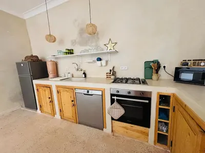 a small kitchen with a stove and a microwave at Riad Dar tiegezh in Marrakech