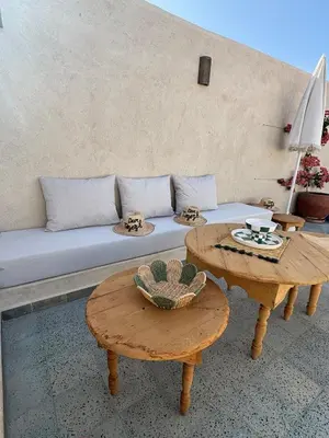 a living room with a couch and two tables at Riad Dar tiegezh in Marrakech