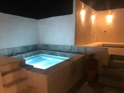 a hot tub in a room with some stairs at Riad Dar tiegezh in Marrakech