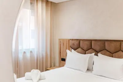 a bedroom with a bed with white pillows and a window at New 2BR AC 5min from City Center-4 to 5Guests in Marrakech