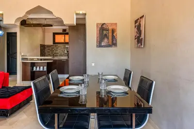 a dining room with a table and chairs at Marrakech-Piscines-Salle Sport - 5 min du stade in Marrakech