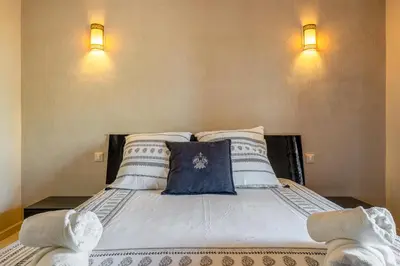 a large white bed with two lights on the wall at Marrakech-Piscines-Salle Sport - 5 min du stade in Marrakech
