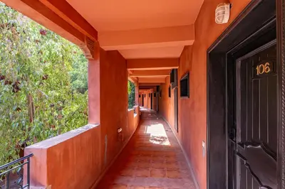 an empty hallway of an orange building with a black door at Marrakech-Piscines-Salle Sport - 5 min du stade in Marrakech