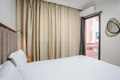 a bedroom with a white bed and a window at The Luxury Gate Duplex Private Pool in Marrakech
