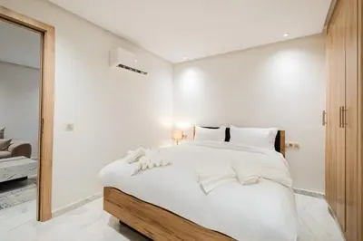 a white bedroom with a large bed with white sheets at NEW Apartment Central 1BR-Queensize, AC&Terrace in Marrakech