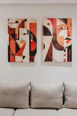 two framed paintings on a wall above a couch at NEW Apartment Central 1BR-Queensize, AC&Terrace in Marrakech