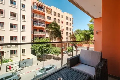 a balcony with a chair and a view of a building at Modern Comfort in Heart of Marrakech in Marrakech