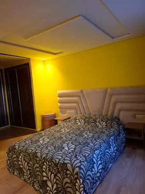 a bedroom with a bed in a yellow wall at Burj malak in Marrakech