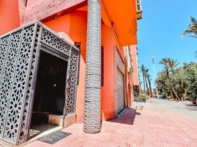 an orange building with a door and a pole at NARJI HOTEL Guéliz in Marrakech