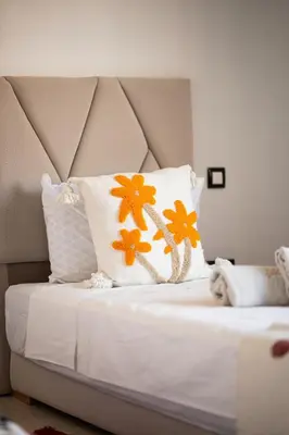 a bed with orange and white pillows on it at Villa Smahane - Comfort & Private Pool in Marrakech