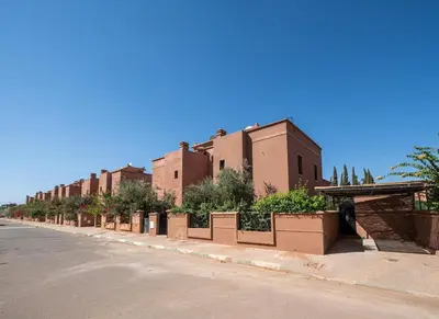 a street with a row of plants on the side of a building at Villa Smahane - Comfort & Private Pool in Marrakech