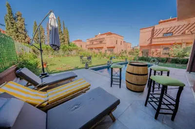 a patio with a couch and chairs and a barrel at Villa Smahane - Comfort & Private Pool in Marrakech