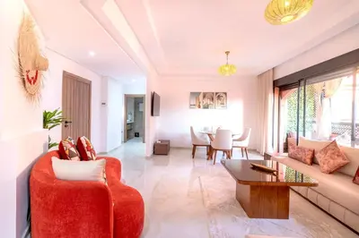 a living room with a red couch and a table at Modern apartment with pool & gym in Marrakech