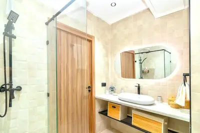 a bathroom with a sink and a shower with a mirror at Modern apartment with pool & gym in Marrakech