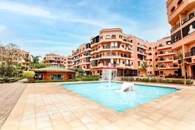 a pool with a fountain in the middle of a building at Modern apartment with pool & gym in Marrakech