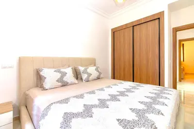 a bedroom with a bed with a wooden door at Modern apartment with pool & gym in Marrakech
