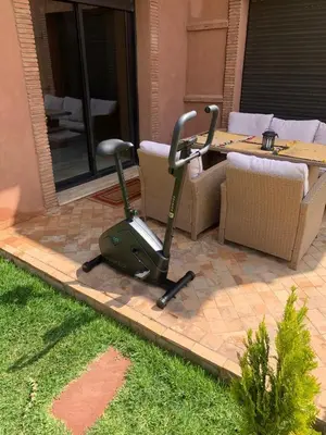 a lawn mower parked on a patio with a table at Luxury private villa with heated pool in Marrakech