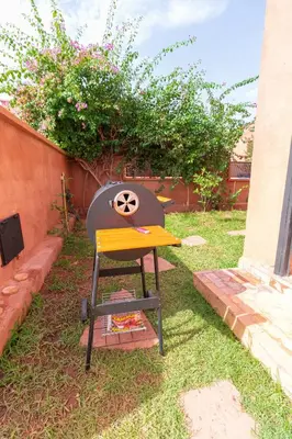a barbecue grill sitting in the grass in a yard at Luxury private villa with heated pool in Marrakech