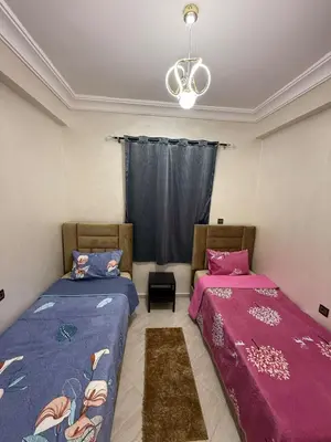 a bedroom with two beds and a chandelier at Moroccan elegance Quiet & Comfort 5min airport in Marrakech