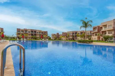 a large swimming pool in front of some apartment buildings at Le Lys - Prestigia Argan - Golf - 6 Prs - Piscine in Marrakech