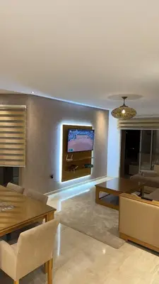 a living room with a flat screen tv on the wall at 3 bedroom apartment prestigia jade in Marrakech