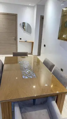 a wooden dining table in a room with a couch at 3 bedroom apartment prestigia jade in Marrakech