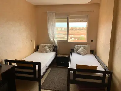 two beds in a small room with a window at Modern appartement in Marrakech in Marrakech