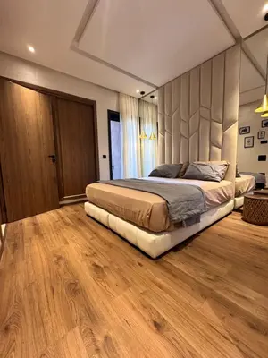a bedroom with a large bed and a wooden floor at Le pavillon gueliz appartement de luxe in Marrakech