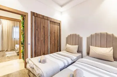 two beds sitting next to each other in a bedroom at Magnifique appartement 2 chambres à Menara Garden Marrakech in Marrakech