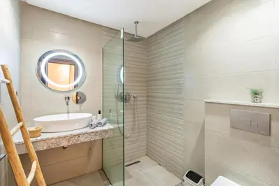 a bathroom with a sink and a glass shower at Magnifique appartement 2 chambres à Menara Garden Marrakech in Marrakech