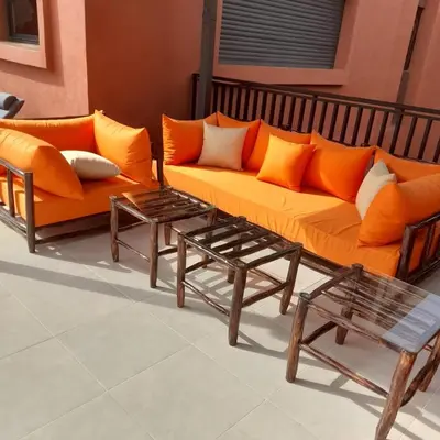 an orange couch and two tables in a room at Magnifique villa spacieuse Route de l'ourika in El Rhechat