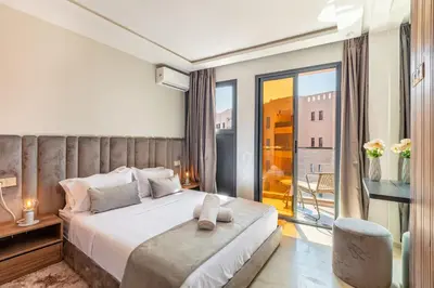 a bedroom with a large bed and a balcony at Elegant 2BR Modern Prime District in Marrakech in Marrakech