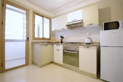 a kitchen with white appliances and a white refrigerator at Appartement à Marrakech Terrasse et piscine in Marrakech