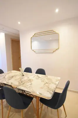 a dining room with a marble table and chairs at Appartement à Marrakech Terrasse et piscine in Marrakech