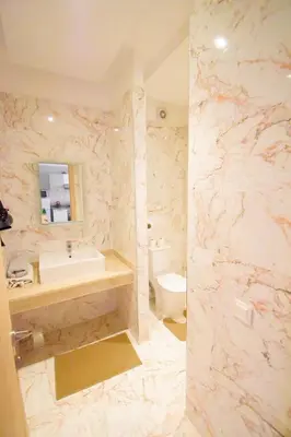 a marble bathroom with a sink and a toilet at Appartement à Marrakech Terrasse et piscine in Marrakech