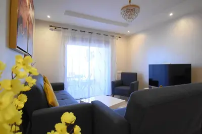 a living room with a couch and a tv at Appartement à Marrakech Terrasse et piscine in Marrakech