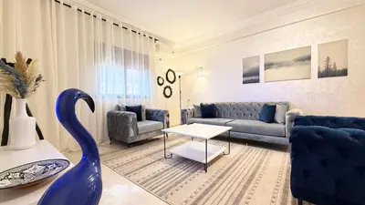 a living room with a blue couch and a table at Cozy apartment in Marrakech