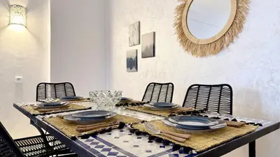 a dining room table with blue plates and a mirror at Cozy apartment in Marrakech