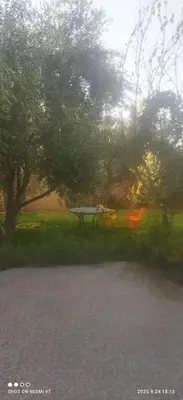 a park with a bench and a table in the grass at Jolie petite villa in Marrakech