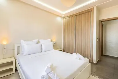 a bedroom with a large white bed with white pillows at Magnifique appartement 2 chambres route du barrage in Marrakech
