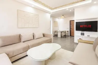 a living room with a couch and a tv at Magnifique appartement 2 chambres route du barrage in Marrakech